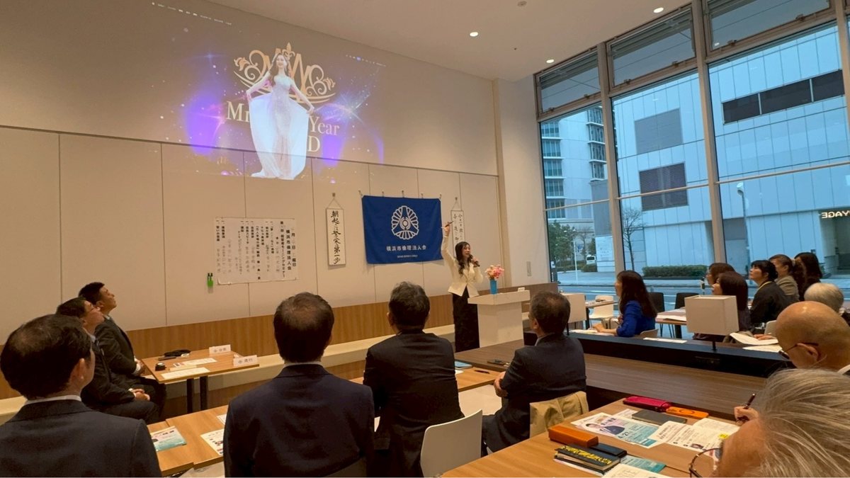 講演会でスクリーンを指しながら話す吉川聖弓