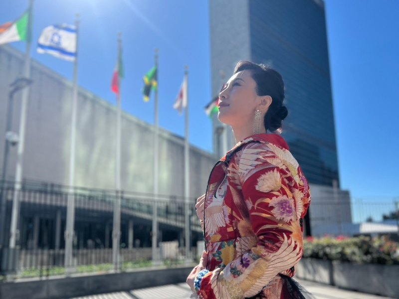 国連本部前の国旗を背に立つ吉川聖弓